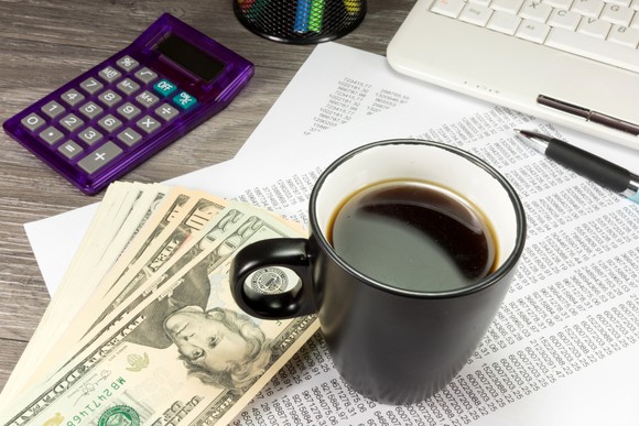 Calculator, cash, paperwork, and coffee