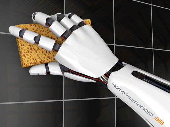 A robot cleans tile in a bathroom with a sponge.