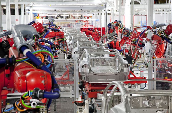Robotics and human labor assembling Tesla vehicles.