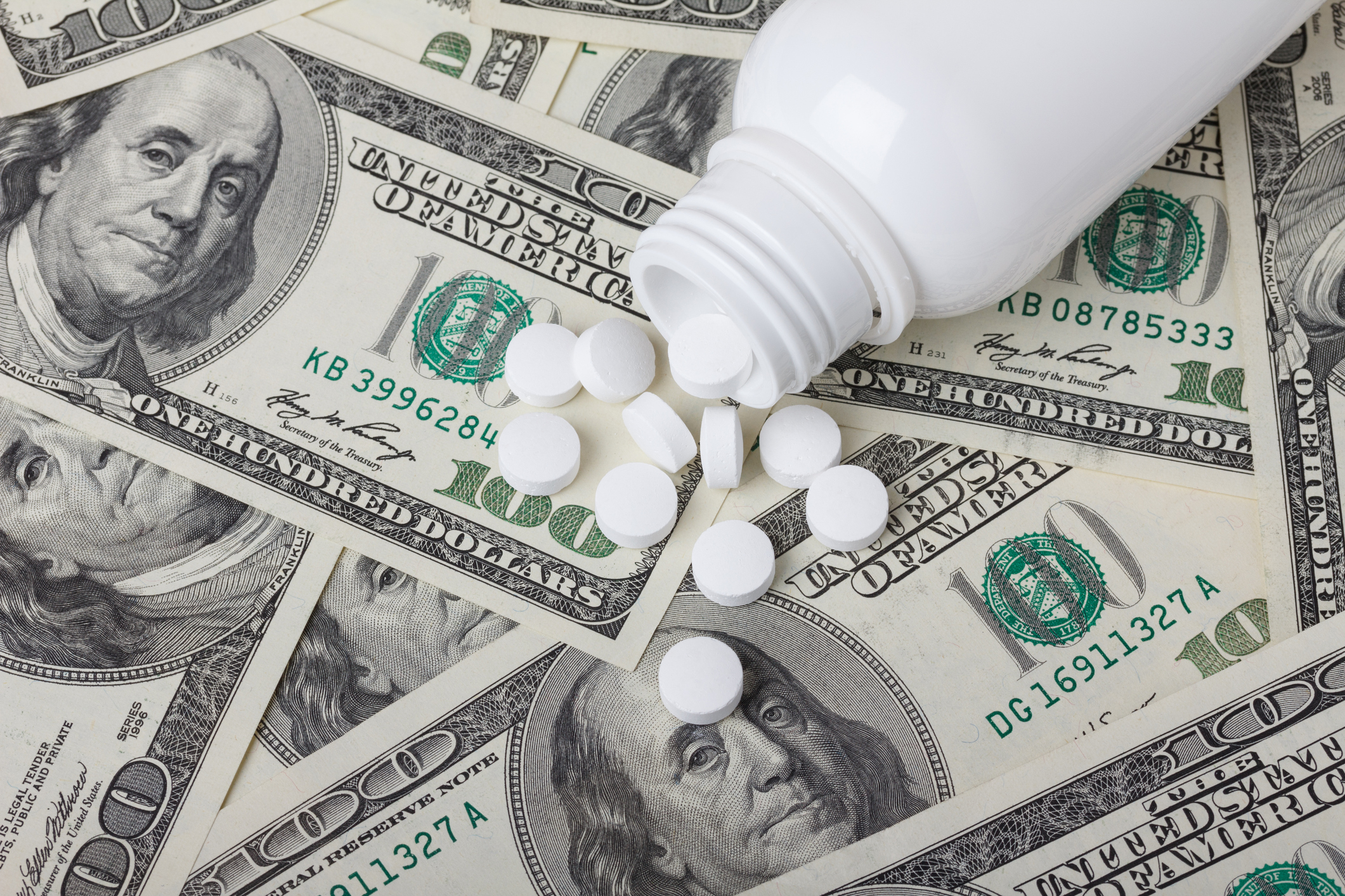 Pills laying on top of money.