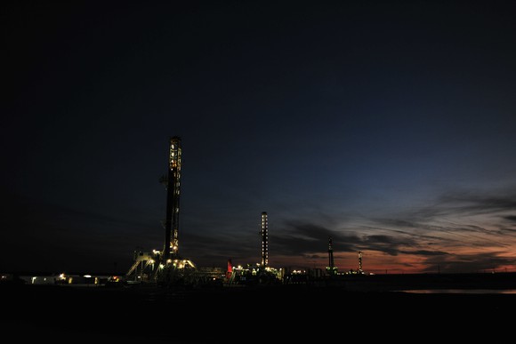 Drilling rigs at dusk.