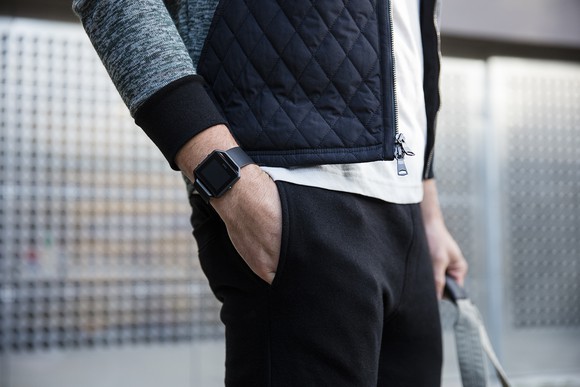 Man wearing a Fitbit Blaze waiting in a train station