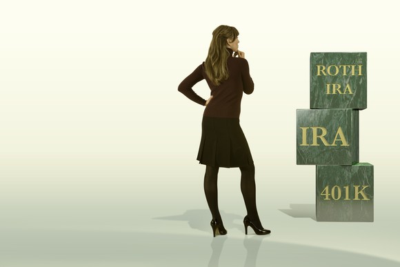 A woman looking at her retirement building blocks of Roth IRA, 401(k), and Traditional IRA.