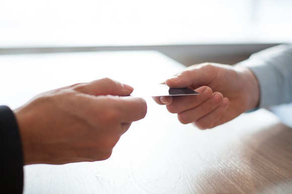 Two hands hold a credit card
