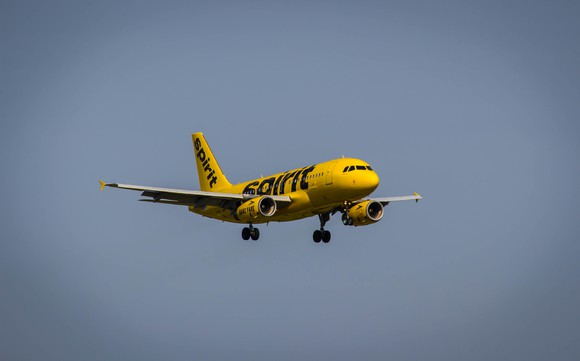 Yellow liveried plane cruising in sky.