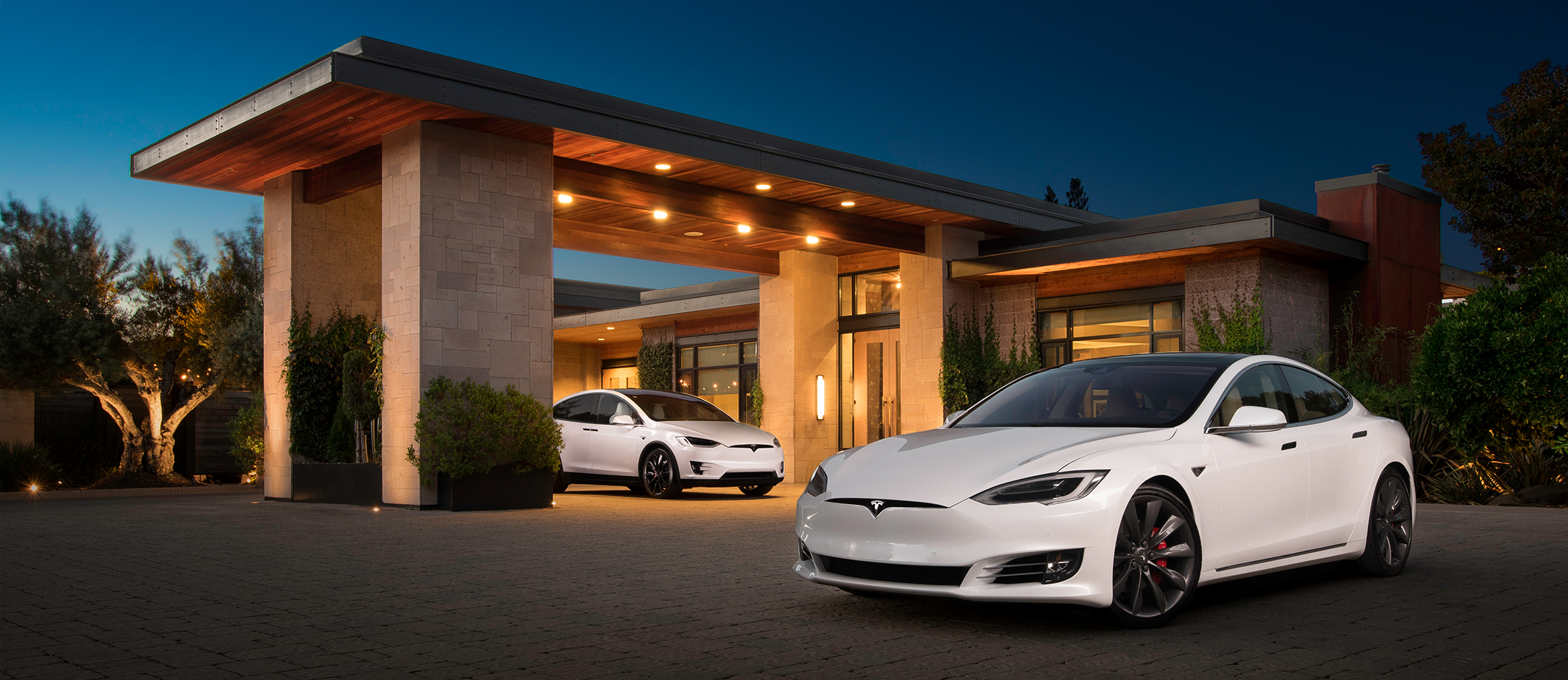 Model S and Model X parked outside a house