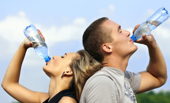 A man and a woman drink water.