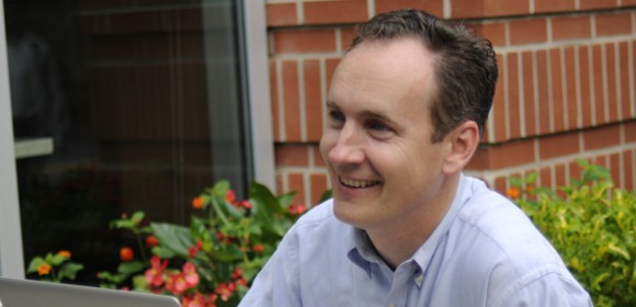 David Gardner seated outside Fool headquarters, smiling.