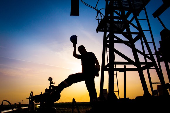 Roughneck in silhouette at oil rig