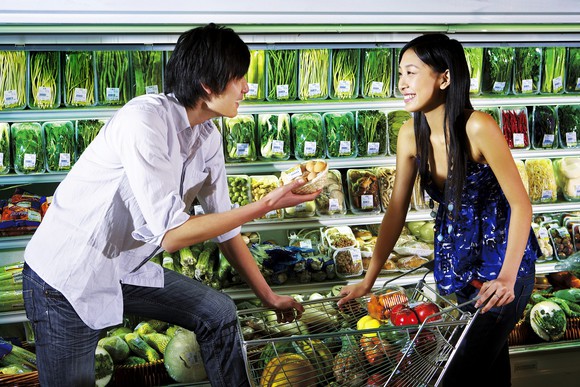 Asian man and woman talking to each other in a supermarket