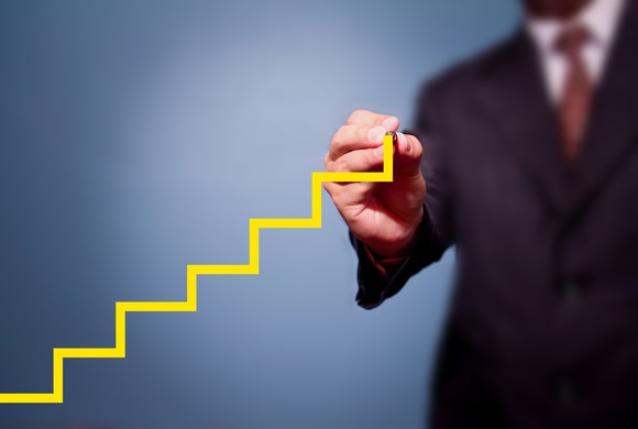 A businessman drawing an ascending stock chart.