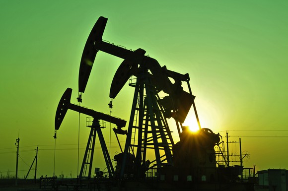 Oil pump-jack in silhouette .