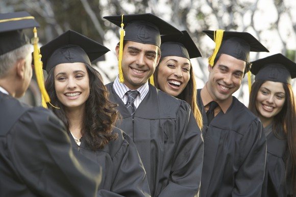 Group of college students in graduation caps and gowns.