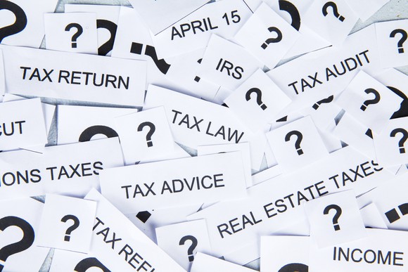 A pile of little papers on which are written words such as "tax return" "tax audit" "tax advice" -- and many simply have big question marks on them