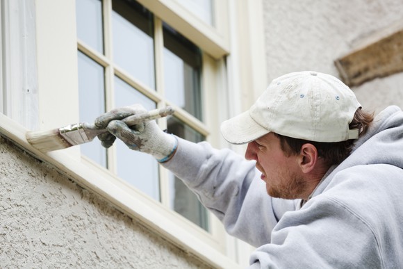 Man painting a window frame