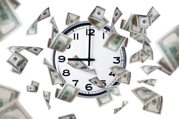 Clock with dollar bills around it.