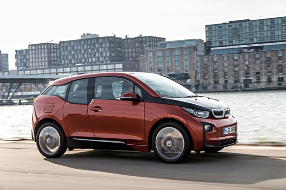 A red BMW i3 being driven in a city