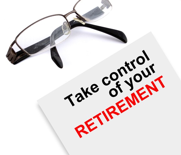 Sign that says "take control of your retirement" next to a pair of glasses.