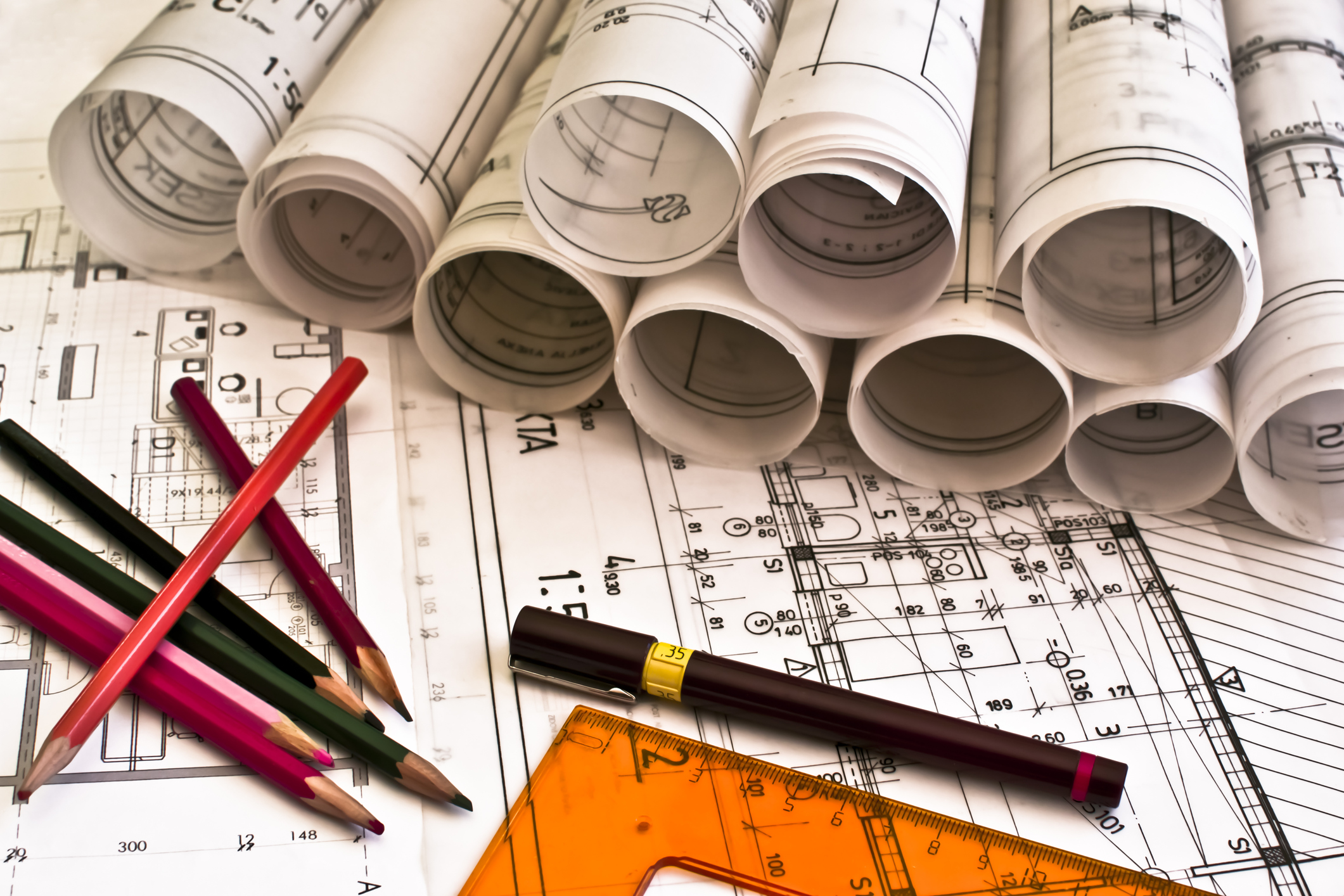Construction plans with pencils lying on a table.