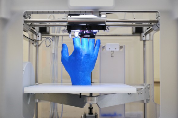 3D printer making a replica of a hand.