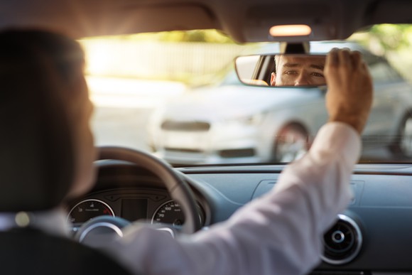 Man looking in the rearview mirror.