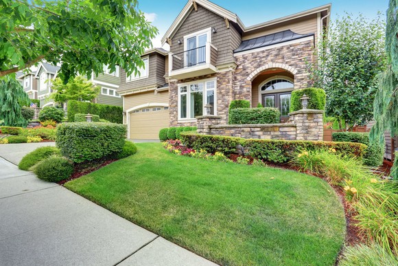 Beautiful new home with manicured front lawn and garden