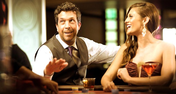 A man and woman playing tables games at the Meadows resort, a Pinnacle-owned casino.