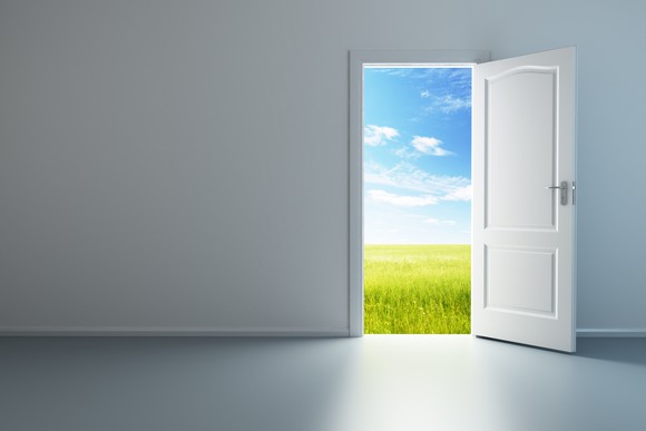 A room with an open door leading to field outside
