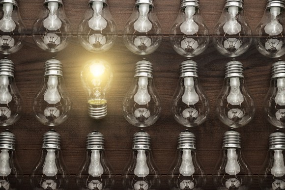 Photo of a group of lightbulbs, with one lit.