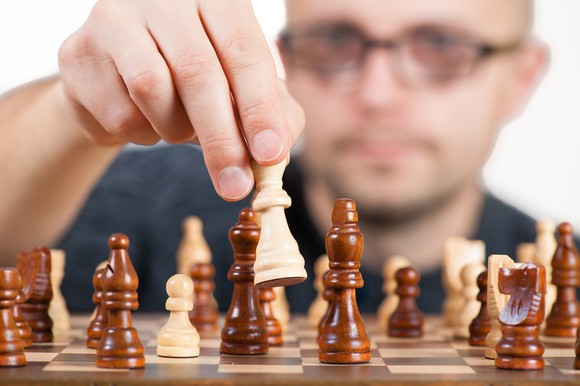 man holding chess piece