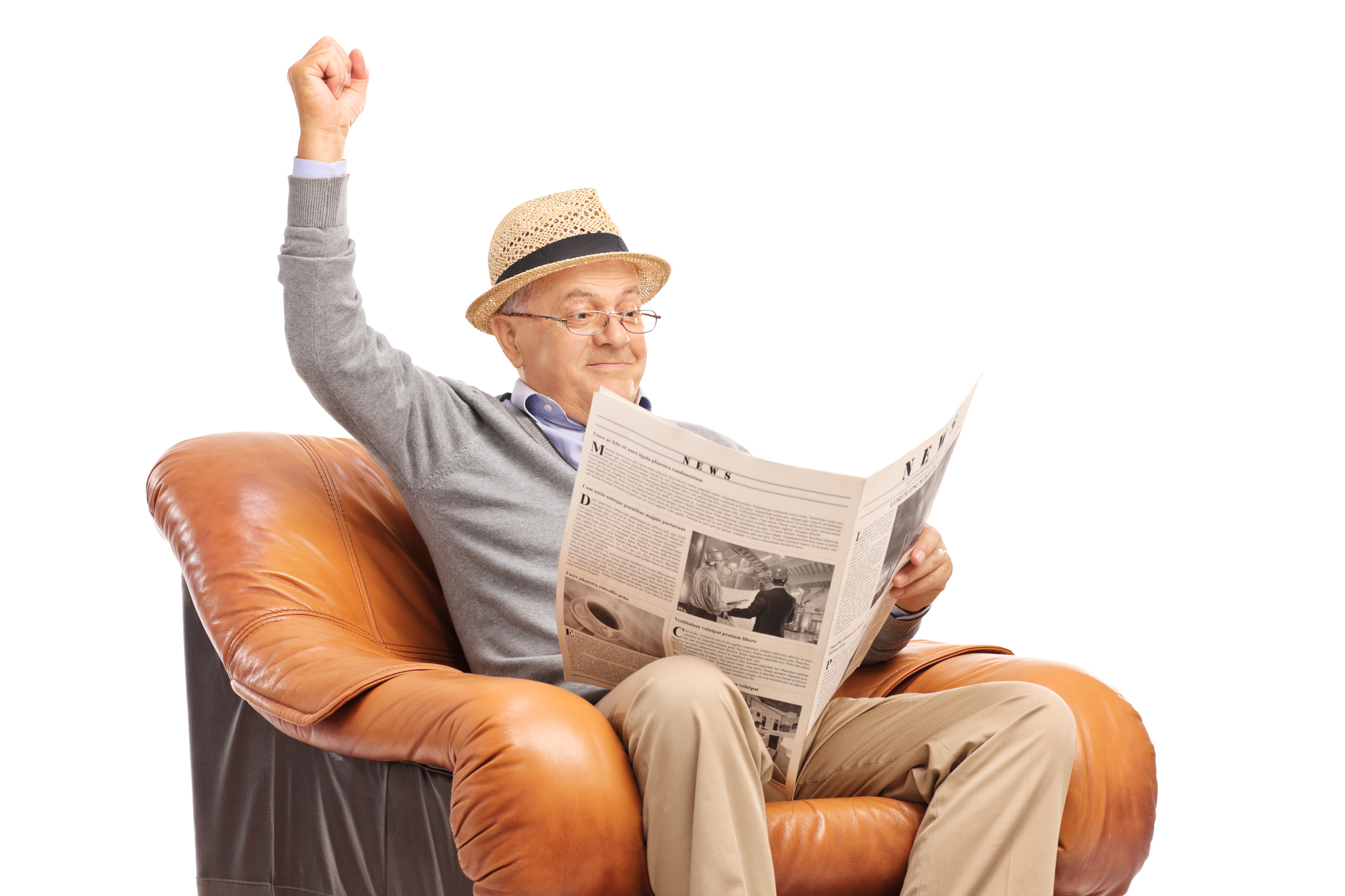 A happy senior sitting in a chair raises his fist to the sky in joy.