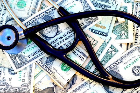 A stethoscope on a stack of paper money