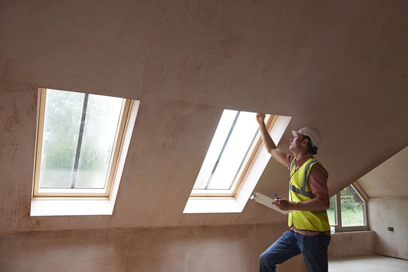 Home inspector checking attic windows