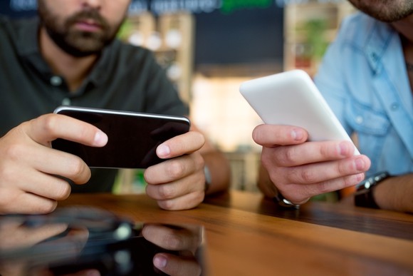 Two people looking at their smartphones.