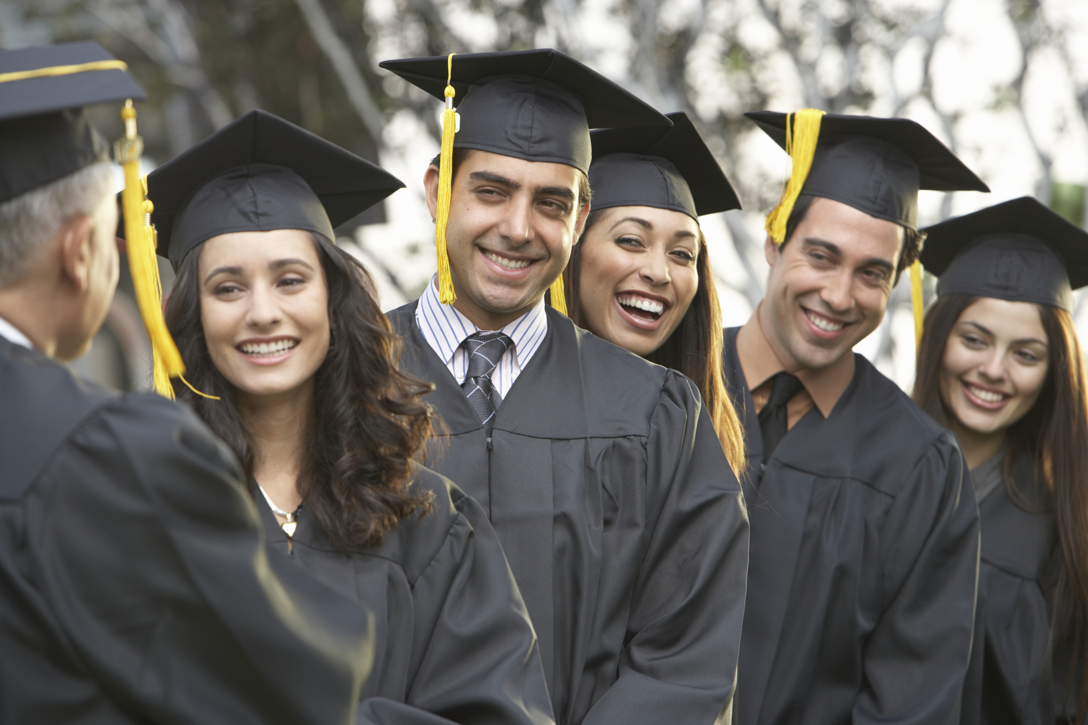 College students at graduation in cap and gown.