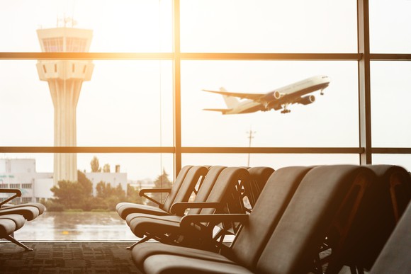 A plane takes off in the background of an airport terminal.