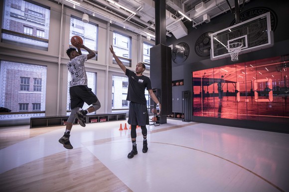 Players practice on the Nike store's basketball floor
