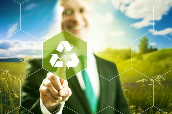 A man pointing with his finger to a recycling logo
