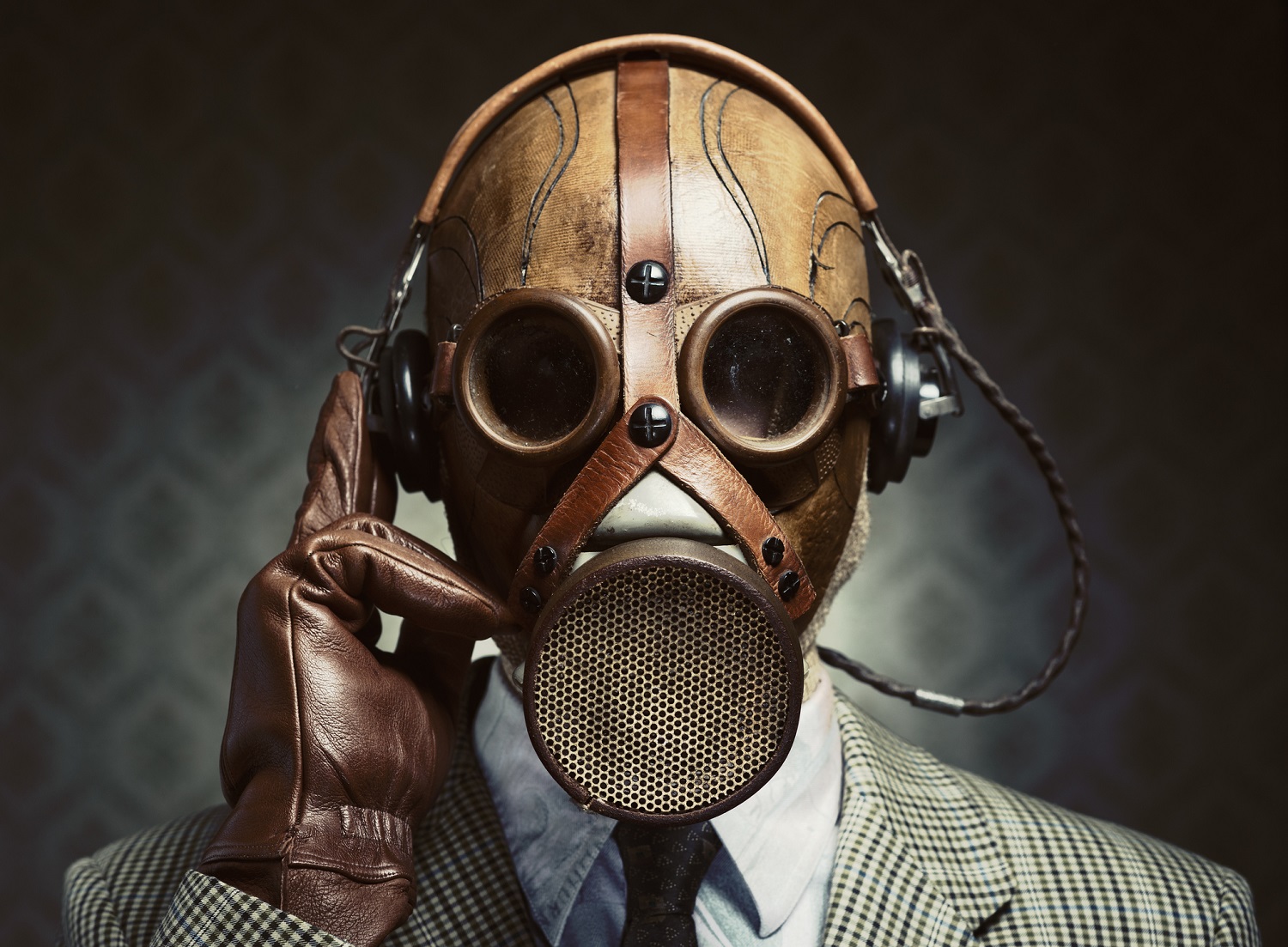 Man in suit, wearing a gas mask.