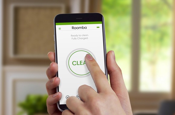 Hand pressing the "Clean" button on iRobot's HOME app