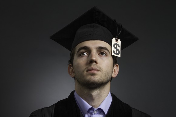A college grad with a dollar sign as the tassel on his graduation cap.