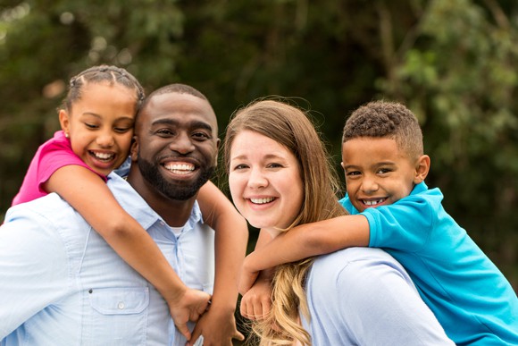 Smiling parents with kids on their backs