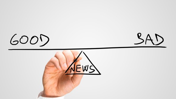 A hand drawing the words "good" and "bad" above a balance point marked "news."