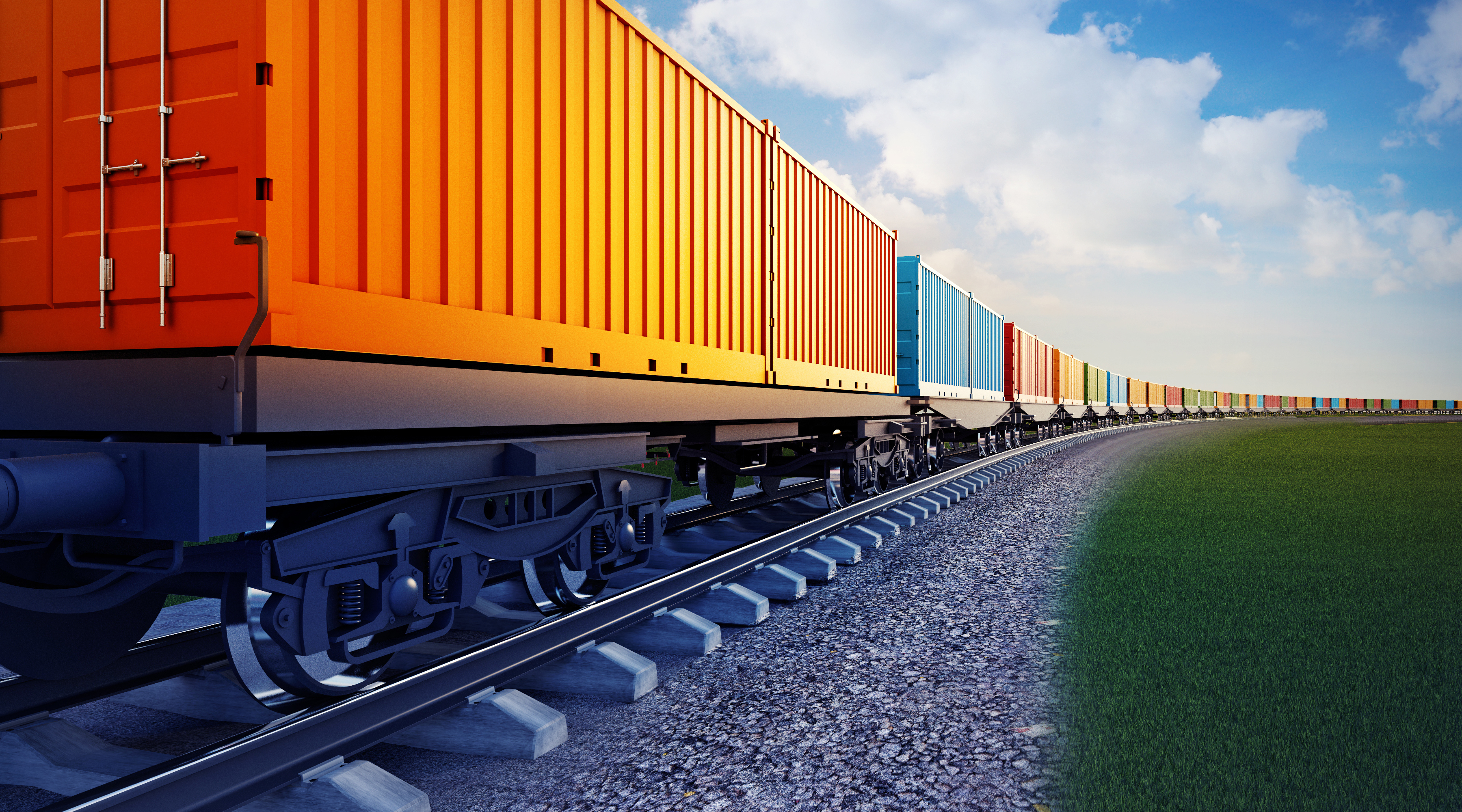 Freight traveling by rail on a partly cloudy day.
