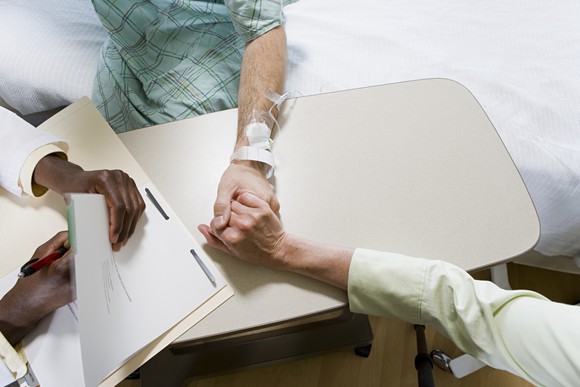 Doctor holding a patient's hand.