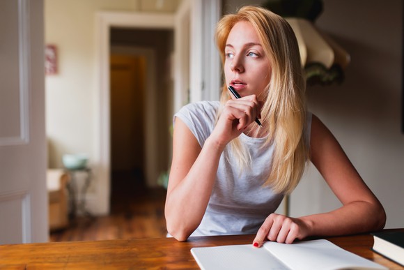 Woman sitting at table thinking