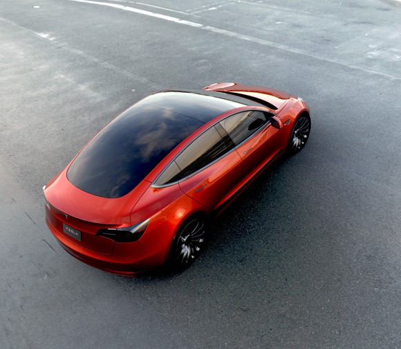 A red Tesla Model 3 sedan viewed from above.