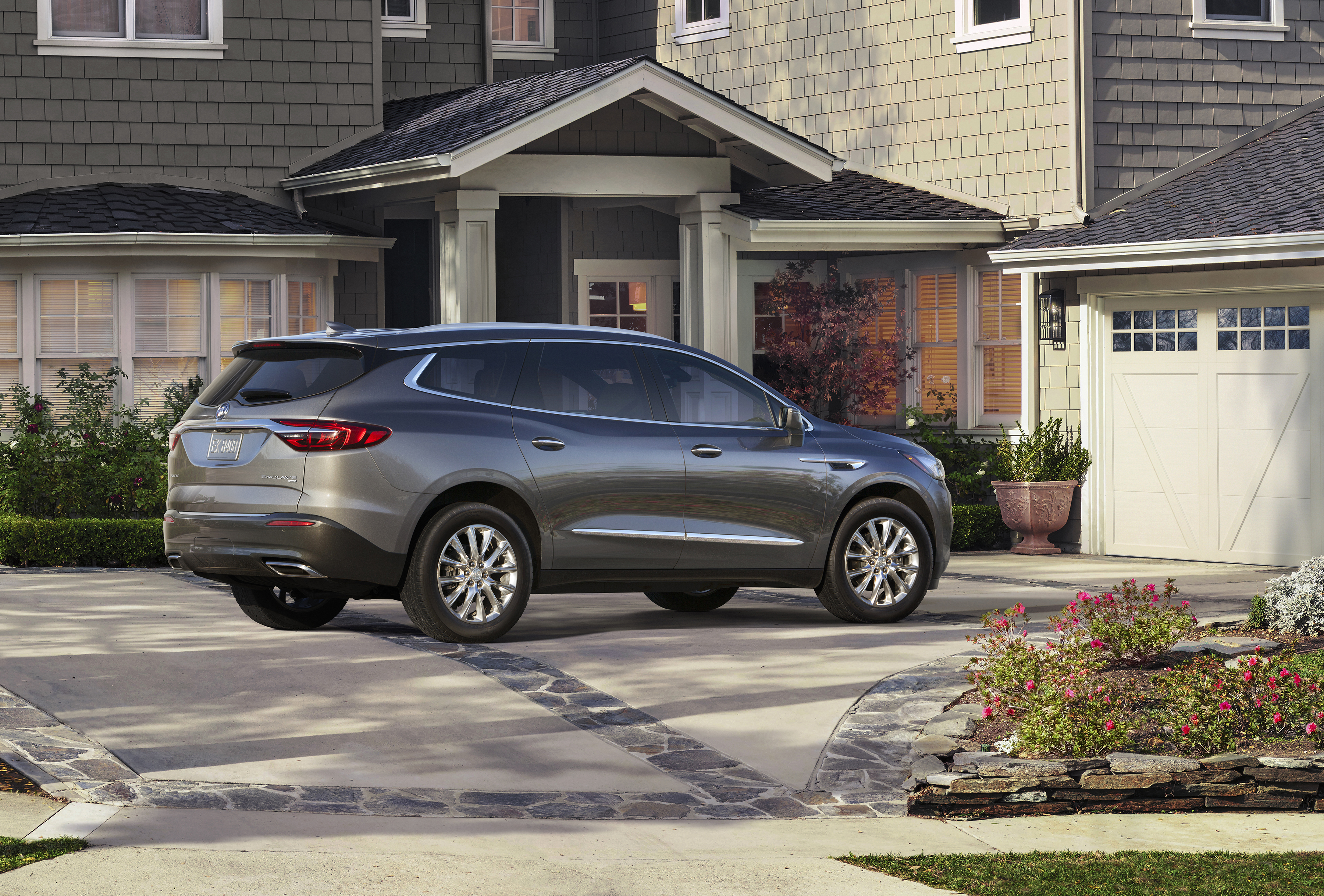 A rear three-quarter view of the new Enclave, parked in an upscale suburban driveway