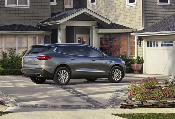 A rear three-quarter view of the new Enclave, parked in an upscale suburban driveway