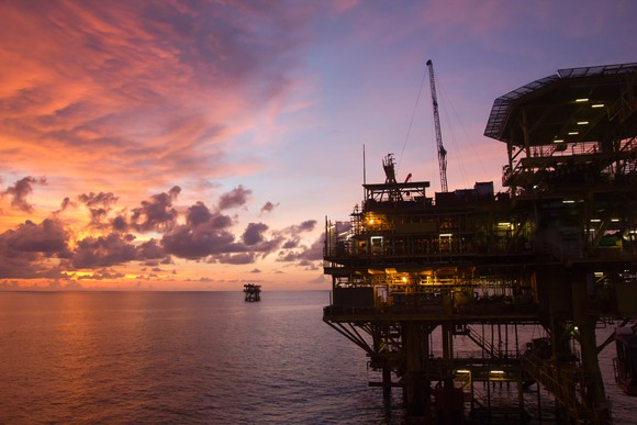 Silhouette of an offshore oil rig at sunset.